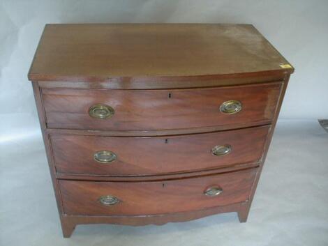 An early 19thC mahogany bow front chest of three graduated drawers with