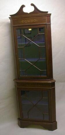 An Edwardian mahogany marquetry corner cabinet with swan neck pediment