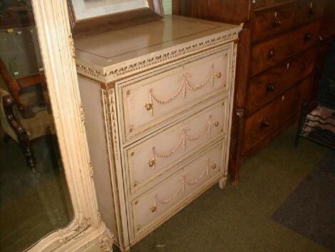 A Louis XVI style parcel gilt chest of three drawers moulded with neo-classical