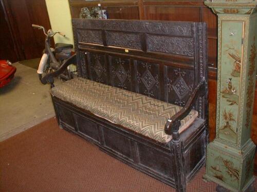 A 17thC carved oak settle with lozenge carved five panel back