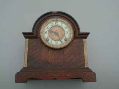 A late 19thC American oak cased mantel clock with 5" gilt and enamel dial