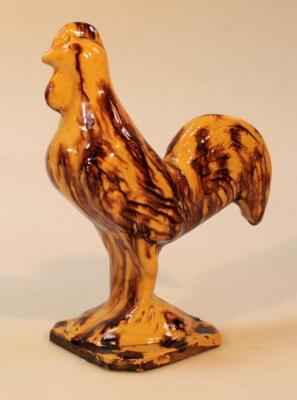 An early 19thC Staffordshire pottery tortoiseshell glazed figure of a cockerel