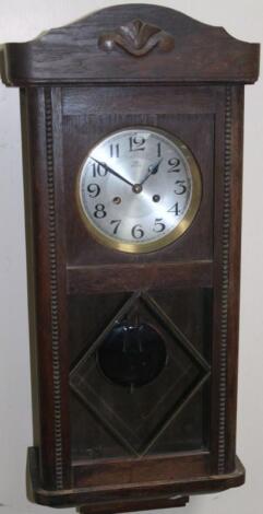 A 20thC oak stained wall clock