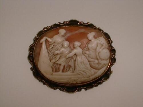 A shell cameo brooch, depicting women and children at a monument, set in