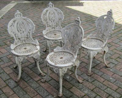 A set of four Victorian cast iron garden chairs.