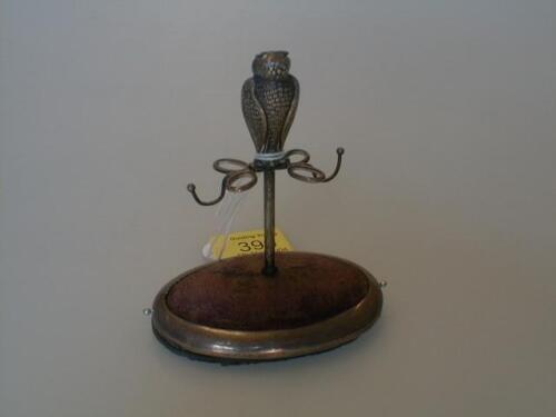 A small silver jewellery stand as an owl on a perch