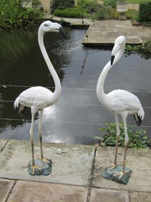 A pair of modern cast metal figures of flamingoes