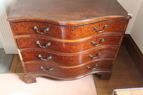 A George III serpentine chest of four graduated drawers