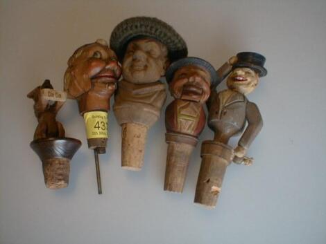 Five various bottle stoppers carved as masks and figures