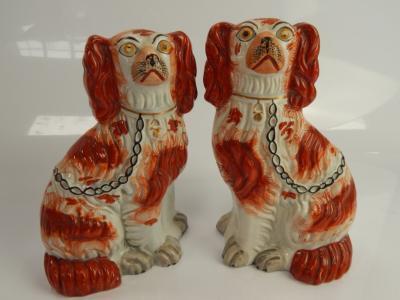 A composite pair of late Victorian Staffordshire seated spaniel comforter dogs