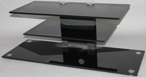 A modern black glass three section television stand