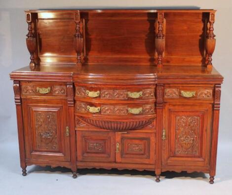 A heavily carved Edwardian walnut sideboard