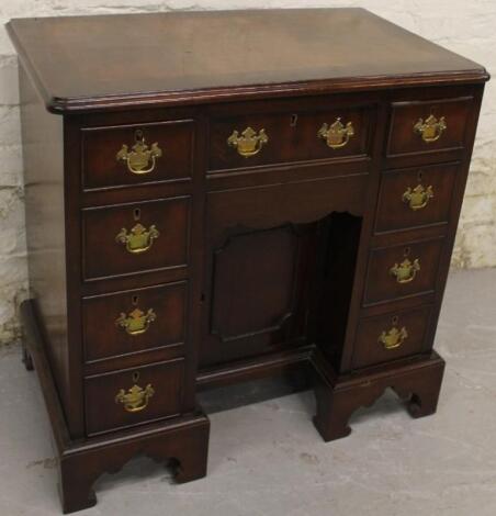 A Queen Anne style mahogany and walnut knee hole desk