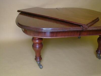 A Victorian mahogany wind out dining table