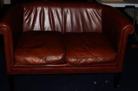 A Laura Ashley two seater leather tan sofa.