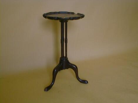 A 20thC mahogany wine table with a circular pie crust top