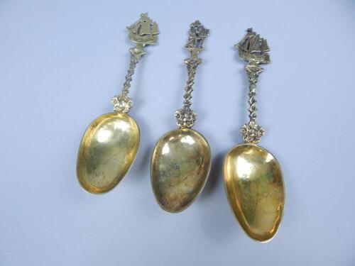 A set of three continental gilt white metal commemorative type spoons
