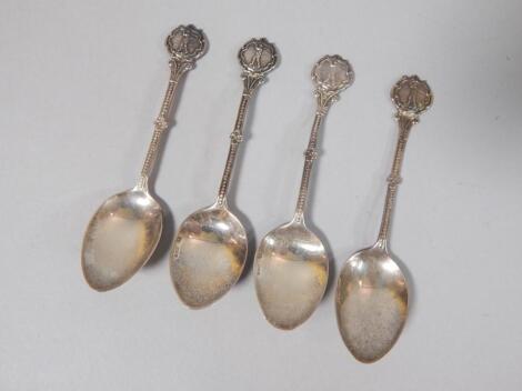 A set of four silver golfing teaspoons.