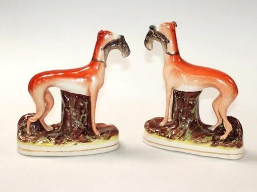 A pair of 19thC Staffordshire pottery greyhound figures