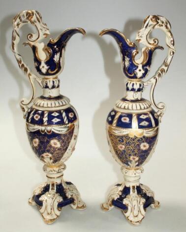 A pair of Edwardian earthenware ewers