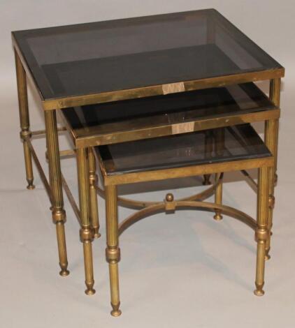 A nest of three brass framed tables