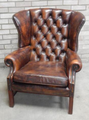 A 20thC brown club wing armchair