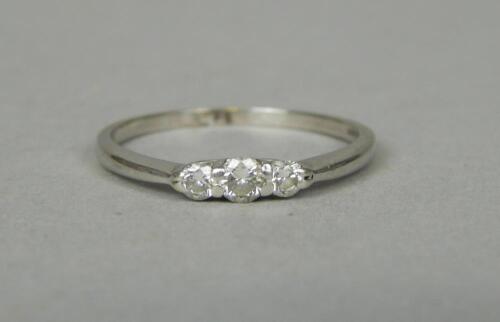 An 18ct white gold (import) three stone diamond ring