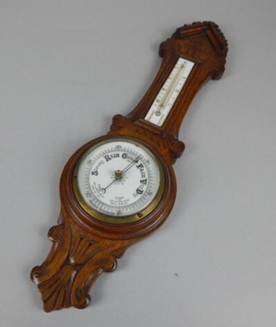 An Edwardian carved oak aneroid barometer