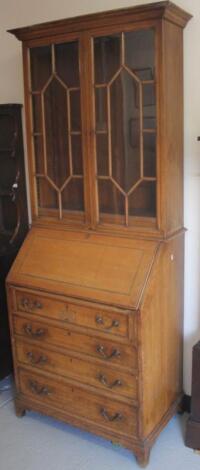 An early 20thC light oak bureau bookcase