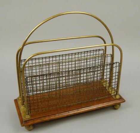 An Edwardian oak and brass two division portable Canterbury or magazine rack