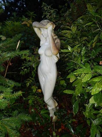 An ornamental garden figure of a semi clad maiden