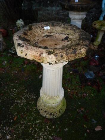 A reconstituted stone octagonal bird bath