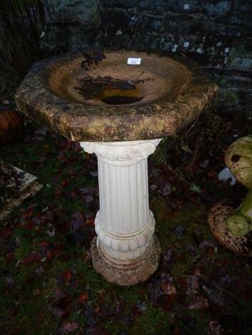 A reconstituted stone octagonal bird bath