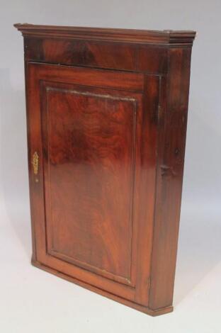 An early 19thC mahogany hanging corner cupboard