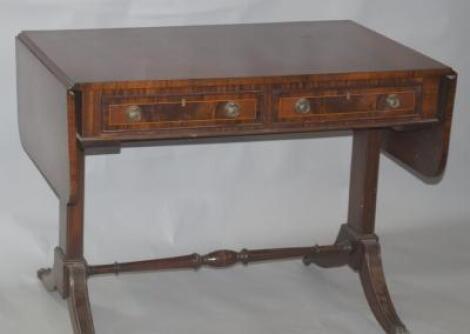 A Regency style mahogany and rosewood cross banded sofa table