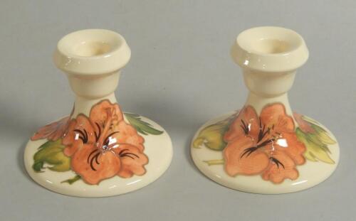 A pair of Moorcroft Hibiscus pattern short candlesticks