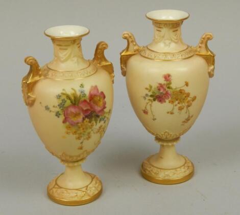 A pair of Royal Worcester blush ivory ground porcelain two handled vases