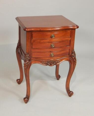 A reproduction mahogany French style bedside cabinet