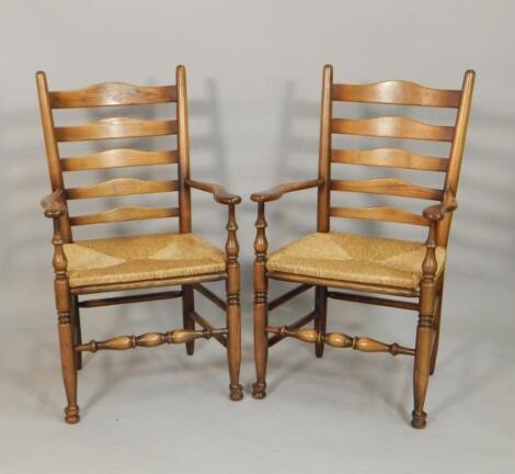 A pair of reproduction oak and ash ladderback carver chairs