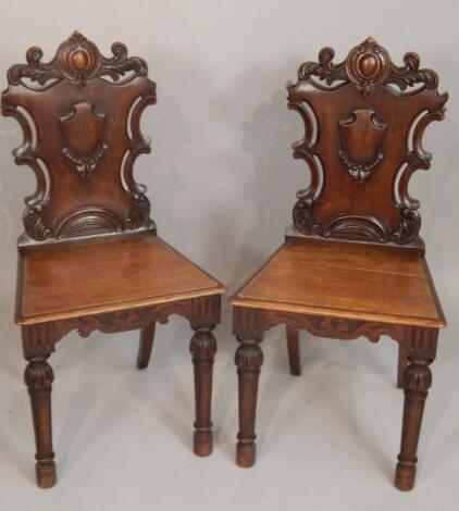 A pair of early Victorian oak hall chairs