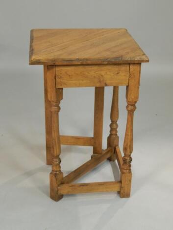 A reproduction oak triangular drop leaf table