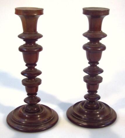 A pair of 19thC turned mahogany candlesticks