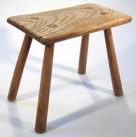 A late 19thC ash and elm light wood four pronged stool