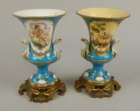 A pair of 19thC Sevres style two handled urns