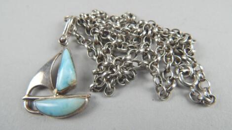 A silver ship pendant and chain