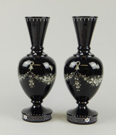 A pair of late 19thC black glass vases