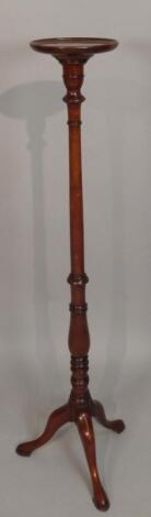 A reproduction mahogany torchere