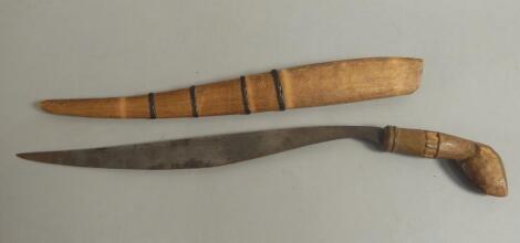 Tribal art. An African dagger with a shaped blade and a wooden scabbard