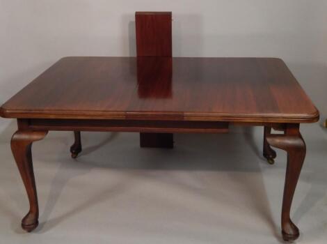 An Edwardian walnut extending dining table