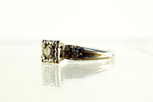 A white metal and diamond set three stone ring